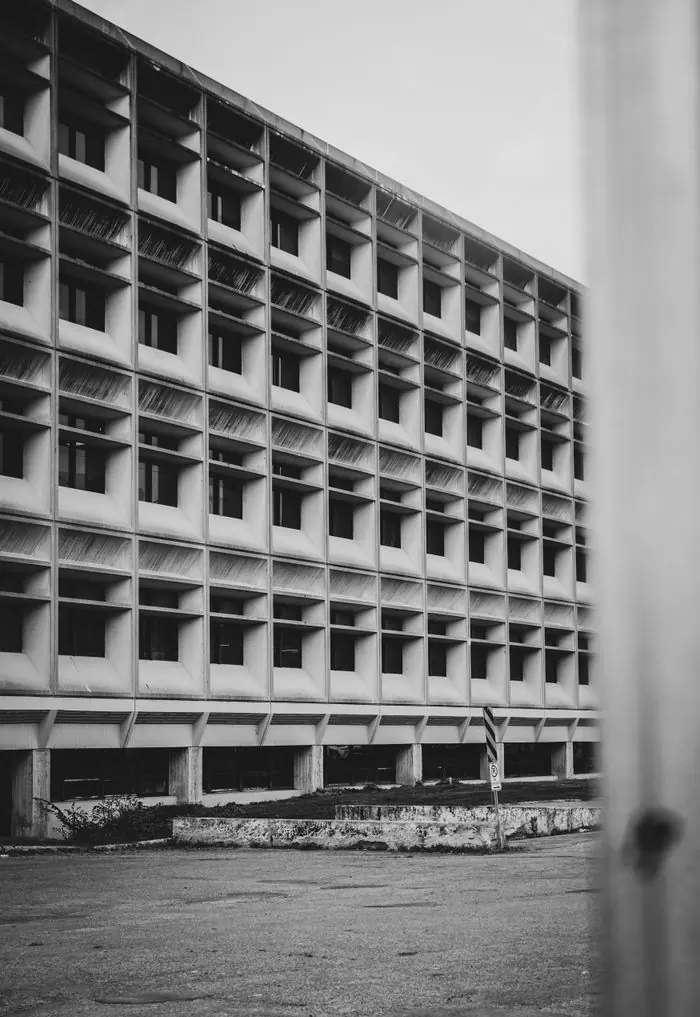 Façade de béton brut, trame régulière d’ouvertures