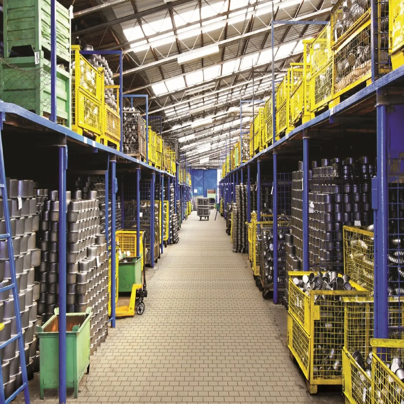 Allée d’entrepôt vue dans sa longueur, sol lisse et racks de stockage